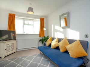 金斯布里奇Waterside Park Annexe的客厅配有蓝色沙发及黄色枕头