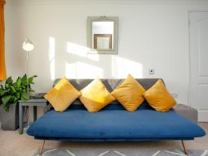 金斯布里奇Waterside Park Annexe的客厅里配有带黄色枕头的蓝色沙发