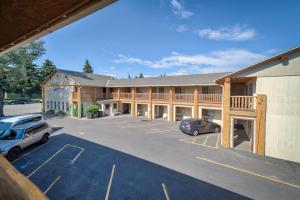 科迪Moose Creek Lodge & Suites的停车场内停放汽车的大型建筑