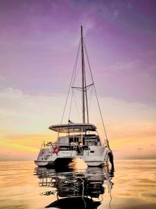 FodhdhooSabba Whitesand Catamaran的白船在日落时分坐在水中