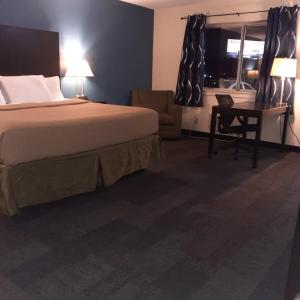 凤凰城Americas Best Value Inn Phenix City的配有一张床和一张书桌的酒店客房