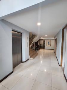 曼谷八月度假酒店的走廊铺有白色瓷砖地板,设有楼梯