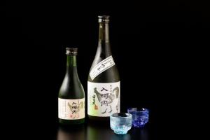Aki日本の秘境で味わう絶品地鶏 ジローのおうち的桌子上放着两瓶葡萄酒,放着一杯
