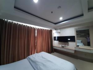 雅加达Cozy Tamansari Hive Cawang by Bonzela Property的一间卧室配有床和带窗帘的窗户