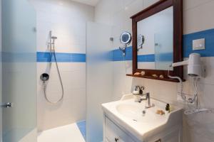 福森Vitusfort Doppelzimmer Edinburgh的浴室配有盥洗盆和带镜子的淋浴