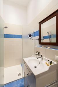福森Vitusfort Doppelzimmer Edinburgh的浴室配有盥洗盆和带镜子的淋浴