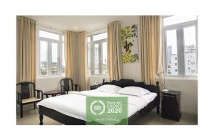 顺化顺化尼诺酒店的一间卧室,配有一张带绿色床垫标志的床