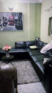 BonabériThe Gulch Apartments的客厅里一张黑色皮沙发,有红色的巴士