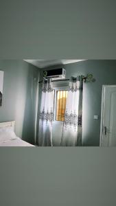 BonabériThe Gulch Apartments的一间卧室配有床和带窗帘的窗户