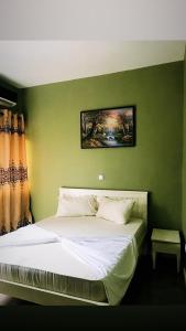BonabériThe Gulch Apartments的一间卧室配有一张带绿色墙壁的床