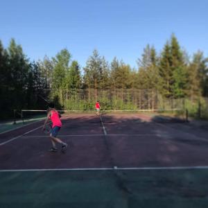NorrfjärdenCharmig stuga på bondgård的两人在网球场打网球