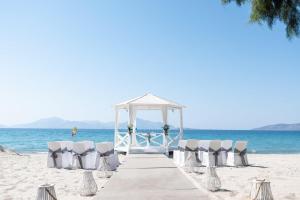 马尔马里E-GEO Easy Living Resort的海滩上带椅子的木板路和凉亭