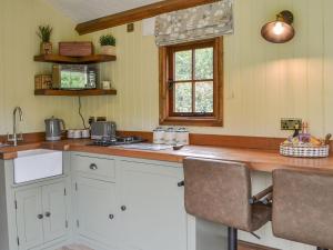 波克灵顿Mayflower - Uk41003的厨房配有白色橱柜、水槽和窗户。
