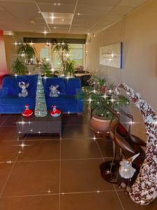 艾格-莫尔特艾格莫特运河酒店的客厅配有蓝色的沙发和盆栽植物