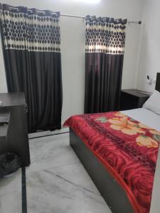 阿格拉hotel khubsaras palace by chhabra's的一间卧室配有一张带红色床单和窗帘的床