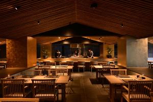 草津Urakusatsu TOU的餐厅设有木桌、椅子和柜台