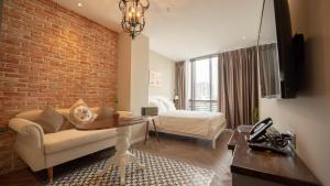胡志明市Celine Living - Central的一间配有沙发和床的房间和砖墙
