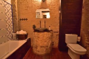 塞维利亚Suite Doña Inés Barrio Santacruz的浴室配有盥洗盆、卫生间和浴缸。
