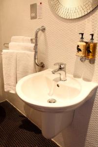 南特威奇柴郡之猫酒店的浴室配有白色水槽和毛巾