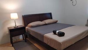 CogonMactan Airport Guesthouse的一间卧室配有一张带黑色床头板和灯的床。