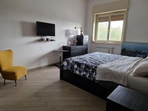 墨西拿La casa di Andrea的一间卧室配有一张床、一台电视和一把椅子