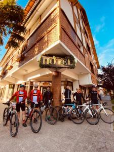 圣马丁德洛斯Tunqueley Hotel的一群人站在建筑物前面,骑着自行车