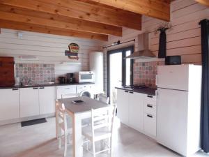 杜埃拉丰坦Chalet cosy climatisé avec parking et Internet的厨房配有白色家电和桌椅