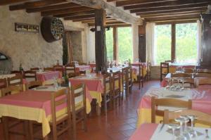 Oix德拉罗维拉旅馆的餐厅设有粉红色和黄色的桌椅