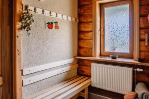 ValmiermuižaBrīvdienu māja ''Rātes'' Valmiermuiža的木制客房设有长凳和窗户。