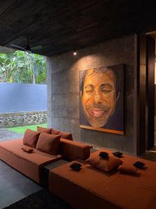 希克杜沃Saffron Robes Living的客厅配有大沙发和绘画作品