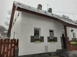 阿贝尔塔米U Berňáků的白色的房子,设有两扇窗户和围栏