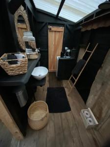 NoirefontaineHome Sweet Dôme in Bouillon的浴室设有黑色墙壁、水槽和镜子