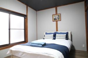 京都Tofukuji Saku Inn（东福寺咲く宿）的一间卧室配有一张带蓝色和白色枕头的床