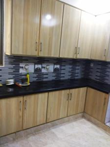 拉合尔Continental Girls Hostel UCP的厨房配有木制橱柜和黑色台面