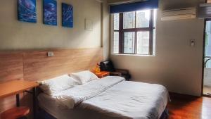 花莲市翼想旅宿-2022營運車站前花蓮民宿的一间卧室配有一张床、一张书桌和一个窗户。
