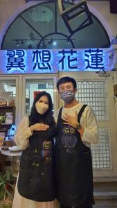 花莲市翼想旅宿-2022營運車站前花蓮民宿的两个人戴面具站在商店前