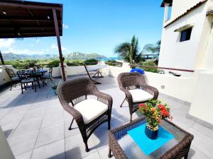 科克Amazing Oceanview rooftop terrace walk to beach的阳台设有带藤椅和桌子的庭院