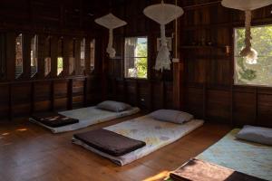 清道Art House at Chiangdao - StarHouse的配有木地板和窗户的三张床