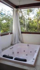 新利马Pousada Canto da Lua的窗户客房内的浴缸