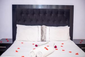 哈拉雷WhiteHouse Lodge的一张黑色床头板和玫瑰床