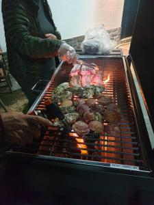 固城郡Iryang Stay的一个人在烧烤架上烹饪食物