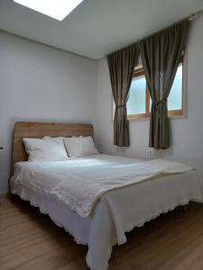 固城郡Iryang Stay的白色卧室设有一张带窗户的床