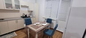 阿特劳Квартира的小厨房配有桌子和蓝色椅子