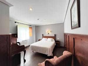 柯米拉斯科米利亚斯酒店的一间卧室配有一张床、一张沙发和一把椅子