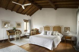 维罗纳伊尔瑞雷德尔阿巴匝酒店的卧室设有白色的床和木制天花板。