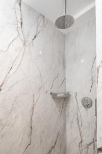 海若克利欧Evans Luxurious Apartment 2的一间带大理石墙壁和淋浴的浴室