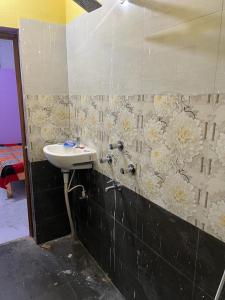 巴特那Riru girlstay的墙上设有带水槽和鲜花的浴室
