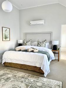弗朗斯胡克The Village Cottage的卧室配有一张带白色床单和枕头的大床。