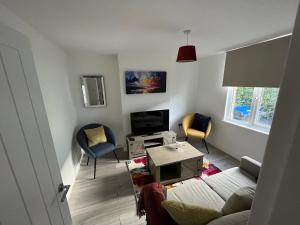 阿德尔斯通3 Bed 2 Lounge House up to 40pc off Monthly in Addlestone by Angel and Ken Serviced Accommodation Great Value for Long-term Stay的客厅配有沙发和两把椅子