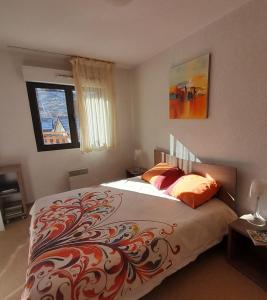 瓦尔堡Val d'Azur Plein sud Face aux Pistes的一间卧室配有一张带彩色毯子的床